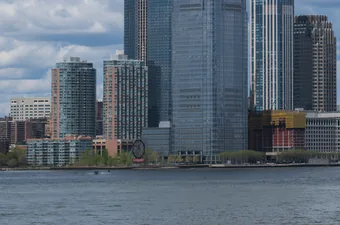 The huge red Colgate Clock on the Jersey City
                        waterfront, seen from the Hudson River at the
                        base of the Goldman Sachs tower.