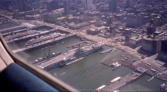 The aircraft carrier Intrepid moored at its
                        Manhattan pier, seen from over the Hudson
                        River.