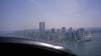 The twin towers of the World Trade Center
                        rising over lower Manhattan, photographed from
                        a light aircraft over the Hudson River.